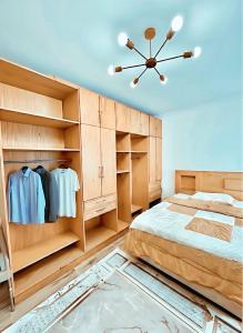 a bedroom with a large bed and wooden cabinets at 2 Bedroom Modern Flat at Zayed in 6th Of October