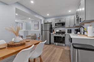 a kitchen with white cabinets and a table and chairs at The Boho Lux Haven Prov in Providence +22 photos