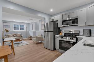 a kitchen with stainless steel appliances and a living room at The Boho Lux Haven Prov in Providence