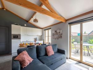 a living room with a blue couch and a kitchen at Westhinder I H21 in Koksijde