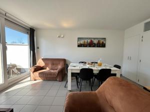 una sala de estar con una mesa y una silla en Westhinder I H30, en Koksijde