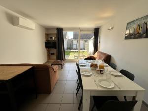 Una sala de estar con una mesa blanca y un sofá. en Westhinder I H30, en Koksijde 8 fotos más