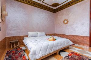 Un dormitorio con una gran cama blanca en una habitación. en Lumir Surf House, en Tamraght Ouzdar 12 fotos más