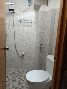 a bathroom with a toilet and a shower at Bolo Airport Dormitel in Mactan Cebu International