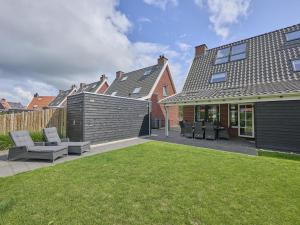 ColijnsplaatにあるBeach deluxeの椅子と柵のある庭のある家