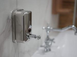 a soap dispenser on a wall next to a sink at Apartments Ro Ma A1 in Novo Selo Požeško