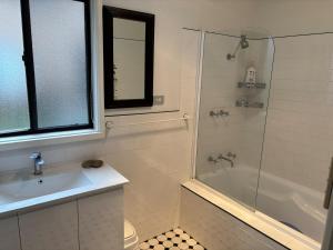 a bathroom with a shower and a sink and a tub at Gravity Stayz in Batehaven +34 photos