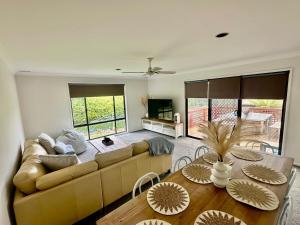 a living room with a couch and a table at Gravity Stayz in Batehaven