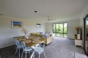 a living room with a table and a couch at Gravity Stayz in Batehaven