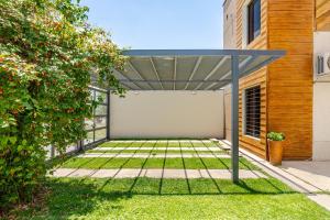 a pergola in the backyard of a house at Departamentos Brown -WiFi 100 MB - Cochera - Parrilla - Aire - TV Cable in San Rafael