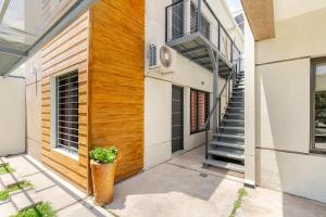 a house with a wooden door and a stairwell at Departamentos Brown -WiFi 100 MB - Cochera - Parrilla - Aire - TV Cable in San Rafael