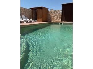 a swimming pool with clear blue water at Stone house with private pool in Agua Amarga in Los Cerrillos +30 photos