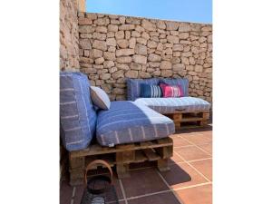 two blue couches sitting next to a stone wall at Stone house with private pool in Agua Amarga in Los Cerrillos