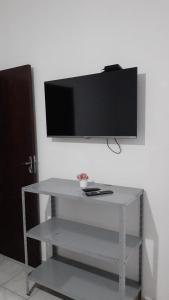a white table with a tv on a wall at Chácara Pedacinho do Céu in Socorro