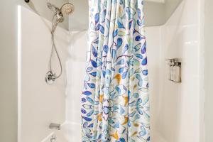 a shower curtain in a bathroom next to a tub at Sip and Hike! Autumn Escape 12 Mi to Traverse City in Grawn +16 photos
