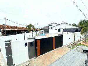 an external view of a house with white walls at Zar House With Swimming Pool in Malacca