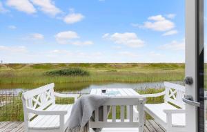 een witte tafel en stoelen op een veranda met een meer bij 3 Bedroom Stunning Home In Vestervig in Vestervig +20 foto's