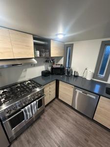 a kitchen with stainless steel appliances and wooden cabinets at Hidden Oasis in Victoria, BC in Victoria