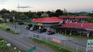 a building with cars parked in a parking lot at Hotel & Restaurante Tabacones in Guácimo