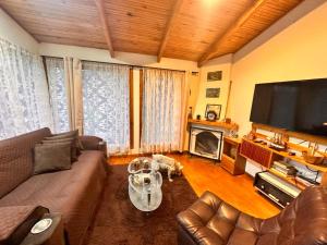 a living room with a couch and a flat screen tv at cabañas Arcoíris del lago Nº 5 in Pasto