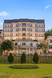 a large tan building with a sign on it at SONG HONG VIEW HOTEL in Lao Cai