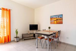a dining room with a table and chairs and a tv at Departamentos Brown -WiFi 100 MB - Cochera - Parrilla - Aire - TV Cable in San Rafael