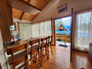 a kitchen with a table and chairs and a large window at cabañas Arcoíris del lago Nº 5 in Pasto