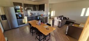 a kitchen and living room with a wooden table at Agréable chambre in Prévessin +10 photos