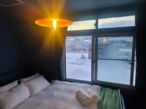a bedroom with a window with two towels on a bed at Rusutsu Ski Stay111 in Rusutsu