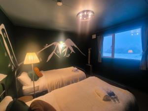 a hotel room with two beds and a window at ルスツリゾート車5分大人数向け貸別荘RusutsuSkiStay111BBQ無料貸し出し花火OK in Rusutsu +79 photos