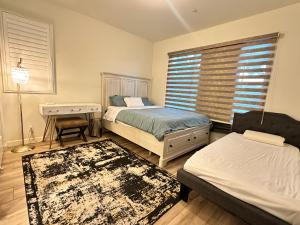 a bedroom with two beds and a desk and a window at Private suite downstairs in Irvine