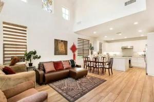 a living room with a couch and a table and a kitchen at Private suite downstairs in Irvine