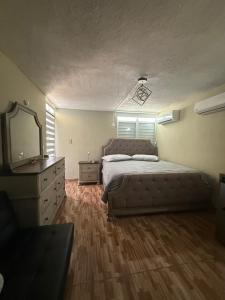 Un dormitorio con una cama, una cómoda y un espejo. en Colombiano boricua, en Quebradillas
