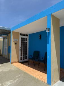 un patio con 2 sillas y una pared azul en Colombiano boricua, en Quebradillas