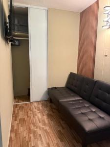 Una sala de estar con un sofá y un televisor. en Colombiano boricua, en Quebradillas