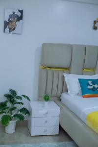a bedroom with a white bed and a white nightstand at Urban Nest suites in Kisii