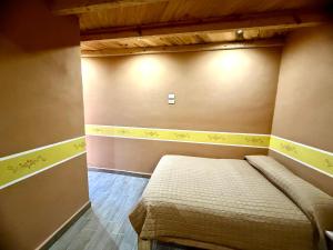 Un pequeño dormitorio con una cama en la esquina en Hotel Nuevo Amanecer, en Real de Catorce