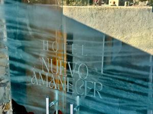 una pared con un cartel que dice "no hasta que estés más cerca" en Hotel Nuevo Amanecer, en Real de Catorce