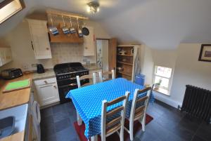 a kitchen with a blue table and chairs in it at Apartment Finchale Abbey in Durham