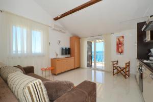 希杰弗朗吉卡Seaside apartments with a swimming pool Seget Vranjica, Trogir - 4284的带沙发的客厅和带阳台的厨房