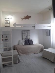 a bedroom with a bed and a bunk bed with a ladder at Sognare sul mare in Granelli