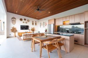 a kitchen with wooden cabinets and a wooden ceiling at KAPI Sebatu Villa in Tampaksiring