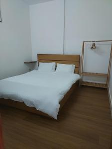 a bed with white sheets and pillows in a room at DINO Home HACOM 2BR city center in Kinh Dinh