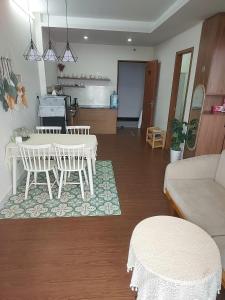 a living room with a table and a kitchen at DINO Home HACOM 2BR city center in Kinh Dinh