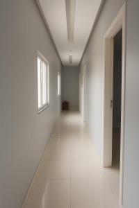 un couloir vide aux murs blancs et une fenêtre dans l'établissement AP disponível para aluguel, à Belém
