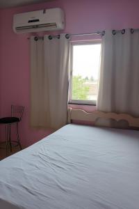 une chambre avec un lit blanc et une fenêtre dans l'établissement AP disponível para aluguel, à Belém