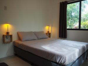 1 dormitorio con 1 cama con ventana y 2 lámparas en Balay Lipay, en Lazi