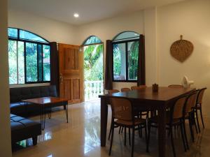 a dining room with a table and chairs and windows at Balay Lipay - Spacious Private House in Siquijor in Siquijor