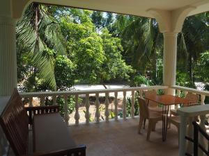 a porch with a table and chairs and trees at Balay Lipay - Spacious Private House in Siquijor in Siquijor