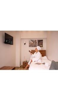 Una mujer sentada en una cama en una habitación. en Falcon pyramids inn, en El Cairo